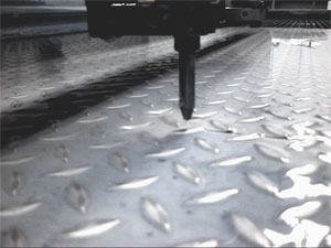 Wasserstrahlschneiden: Ein geb&uuml;ndelter Wasserstrahl wird mit hohem Druck (bis 5.000 bar) aus einer D&uuml;se auf das zu schneidende Material "geschossen".